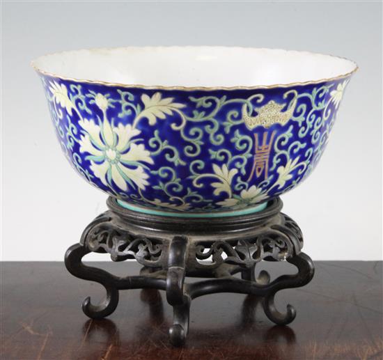 A Chinese blue ground porcelain bowl, Qianlong mark, late 19th / early 20th century, 21.5cm diam., wood stand